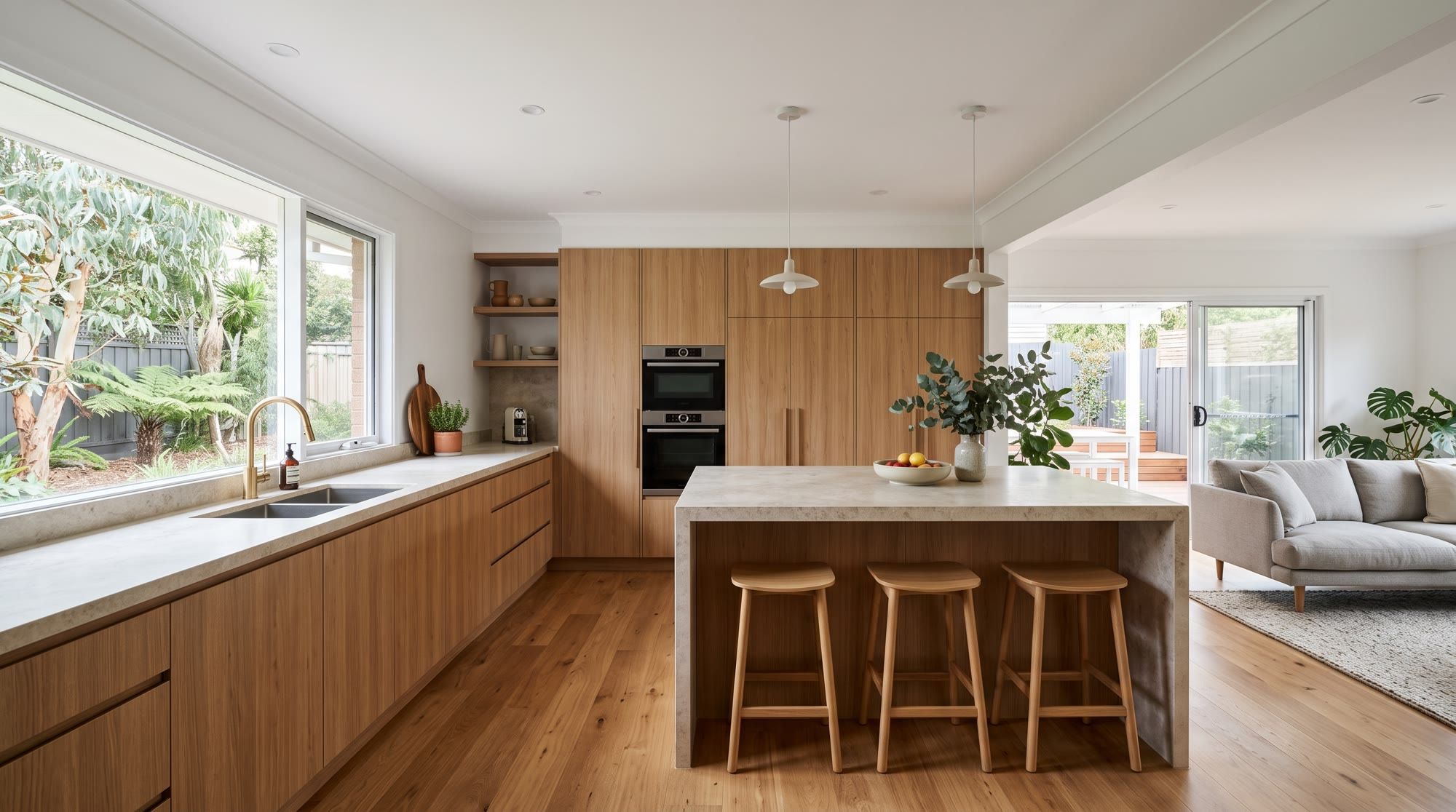 Open-plan kitchen with stone island bench after renovation